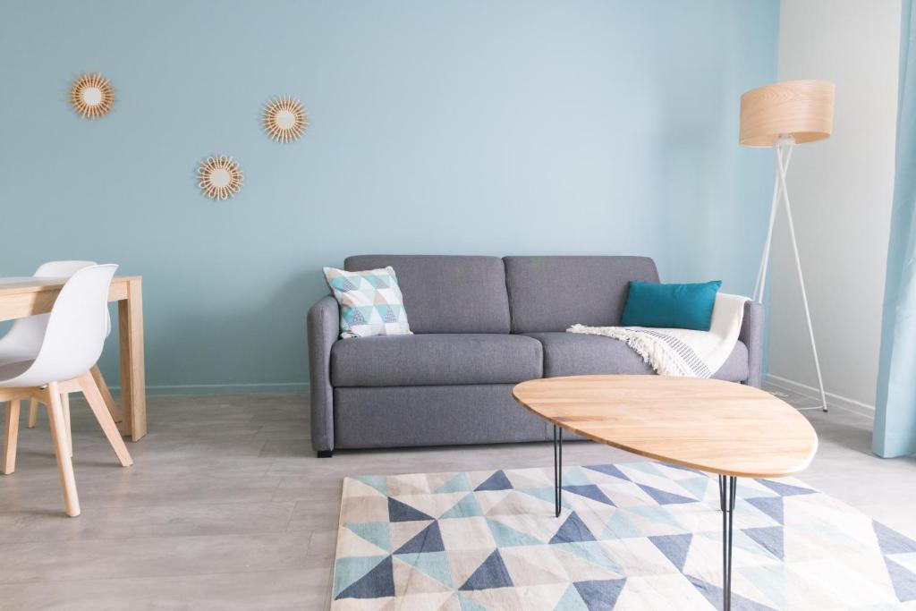 a living room with a couch and a table at A 2 pas du Palais free parking in Avignon