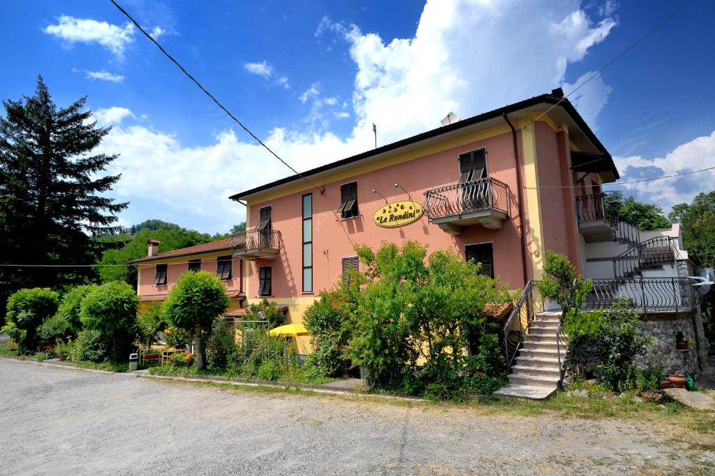 um edifício cor-de-rosa com escadas que o levam até ele em Le Rondini em Riccò del Golfo di Spezia