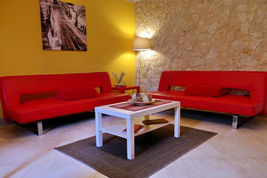 a living room with two red couches and a table at La Nicchia in Noto