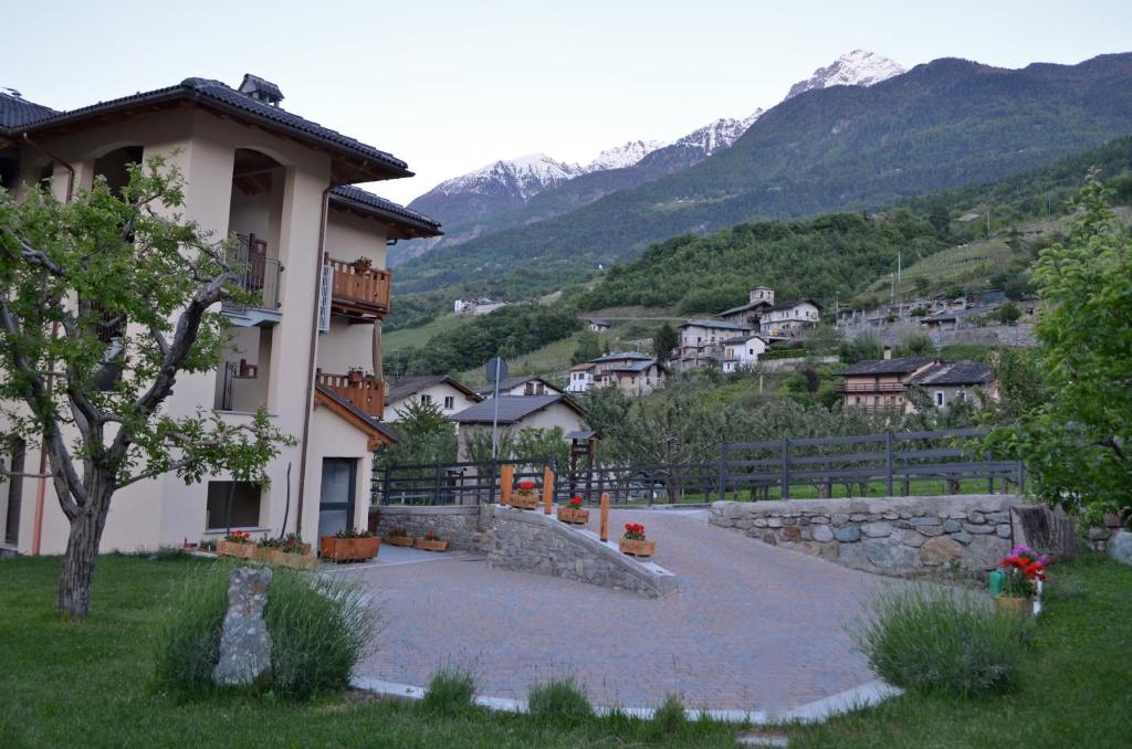 a large building with mountains in the background at La Maison De José in Aosta