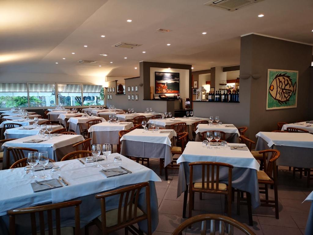 a restaurant with tables and chairs with white tablecloths at Miramaretellaro in Tellaro