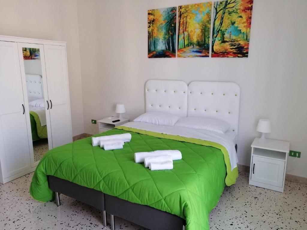 een slaapkamer met een groot bed en een groene deken bij Casagioiosa18 in Palermo