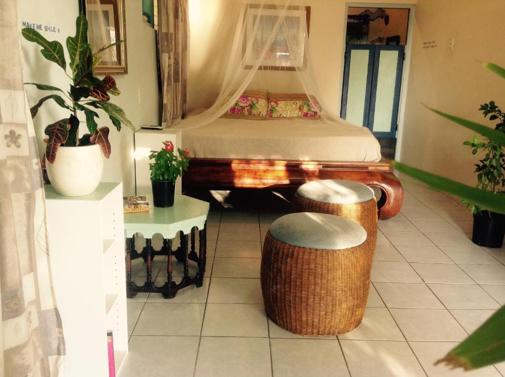 a bedroom with a bed and two stools in it at Magical Garden in Savaneta