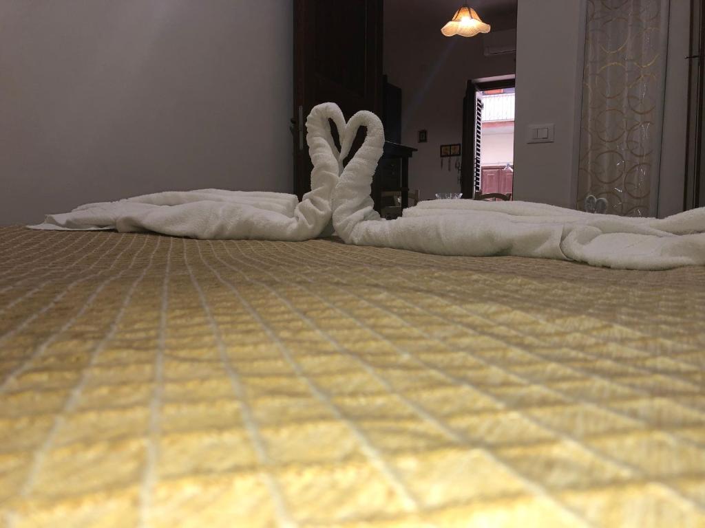 uma cama com toalhas brancas deitadas no chão em Casa Vacanze Salinisti em Marsala
