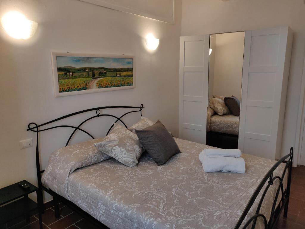 ein Schlafzimmer mit einem Bett mit zwei Kissen und einem Spiegel in der Unterkunft Casa Naldi 2 in Florenz
