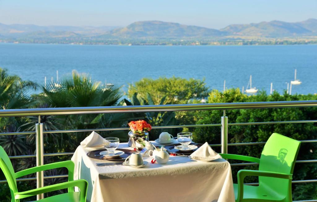 una mesa en un balcón con vistas al agua en Stirling Manor Boutique Guest House, en Hartbeespoort