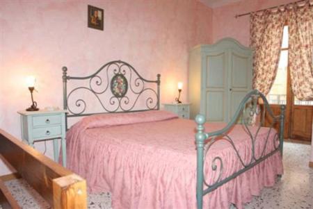 a bedroom with a bed with a pink bedspread at Casa Di Nonna Pina in Marina di Camerota