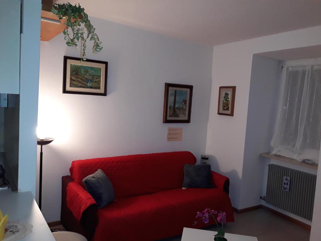 een rode bank in een woonkamer bij Sport and Relax Apartment in Arco