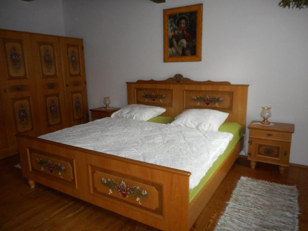 een slaapkamer met een houten bed en 2 dressoirs bij Slovácká chalupa in Ratíškovice
