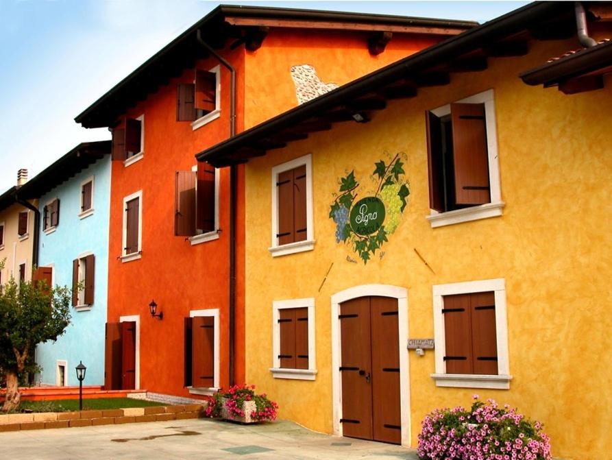 een geel en oranje gebouw met een bord erop bij Agriturismo Pigno in Villafranca di Verona