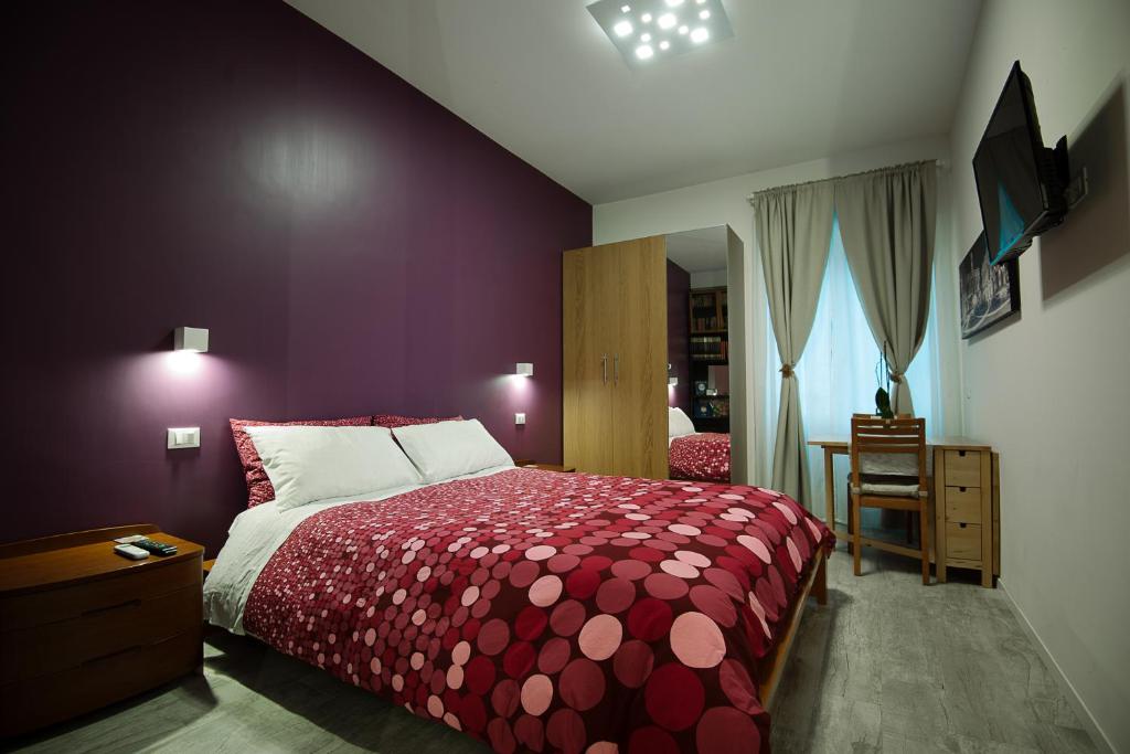 Schlafzimmer mit einem Bett mit einer roten Tagesdecke in der Unterkunft Posada de Liz y Fabrizio in Rom