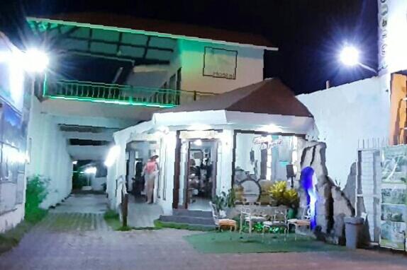 a person standing outside of a building at night at Hostal Gualingo in Santa Rosa