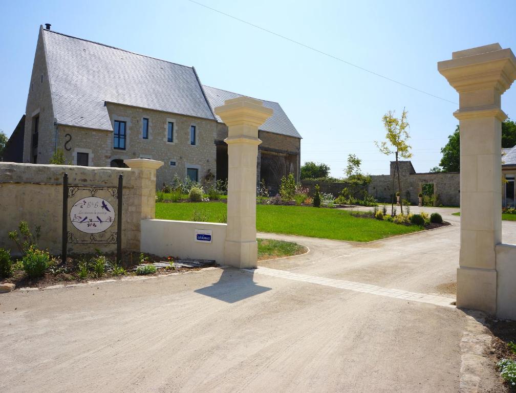 ein Haus mit einem Tor vor einer Einfahrt in der Unterkunft B&B Les Oiseaux de Passage in Isigny-sur-Mer