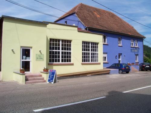 un bâtiment bleu et blanc sur le côté d'une rue dans l'établissement Le Falken, à Philippsbourg