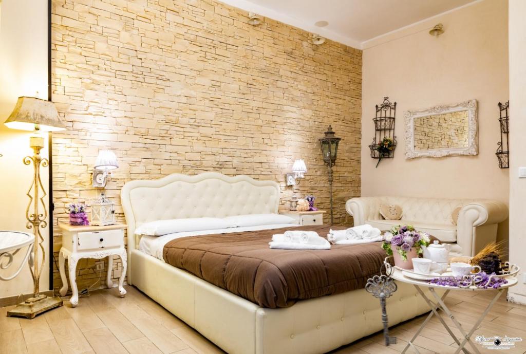 um quarto com uma cama branca e uma parede de tijolos em RomAntic Dreams em Roma