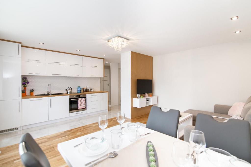 Una cocina y una sala de estar con mesa y sillas. en Apartament Exclusive Centrum, en Białystok