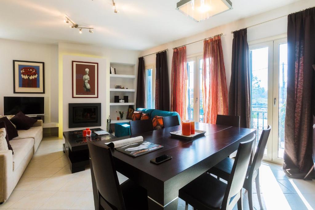 uma sala de estar com uma mesa de jantar e um sofá em Calliope Corfu Apartments em Corfu Town