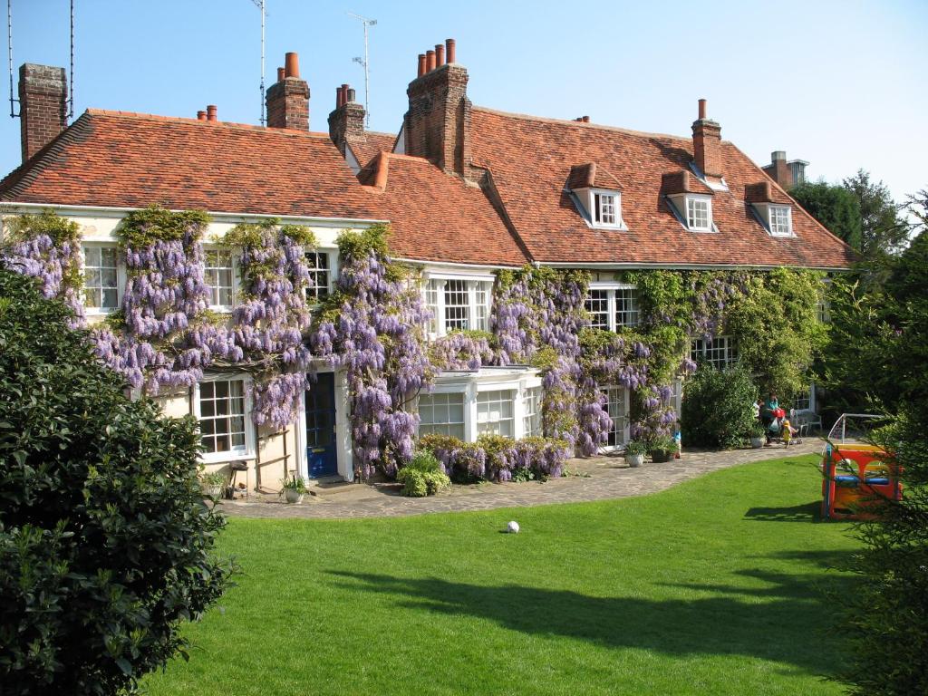 Una casa con glicinas a un lado. en Rothmans B&B, en Chelmsford