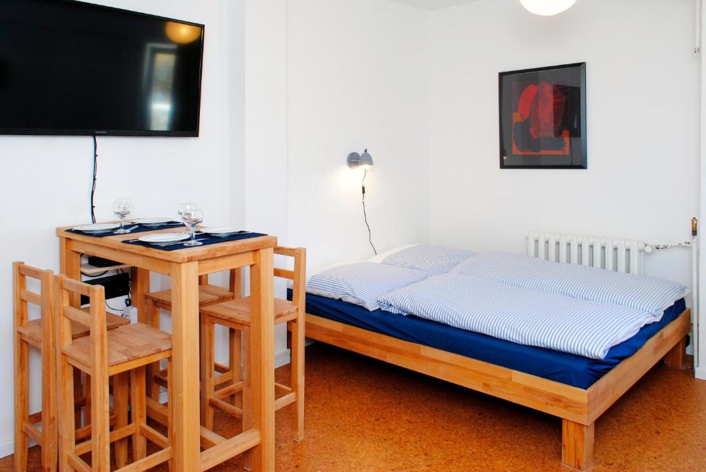 a bedroom with a bed and a table and a tv at Appartement über dem Kino Toni in Berlin