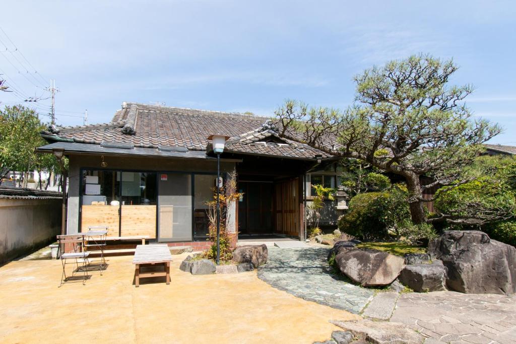 a house with a patio and a tree in front of it at Yuzan Guesthouse in Nara