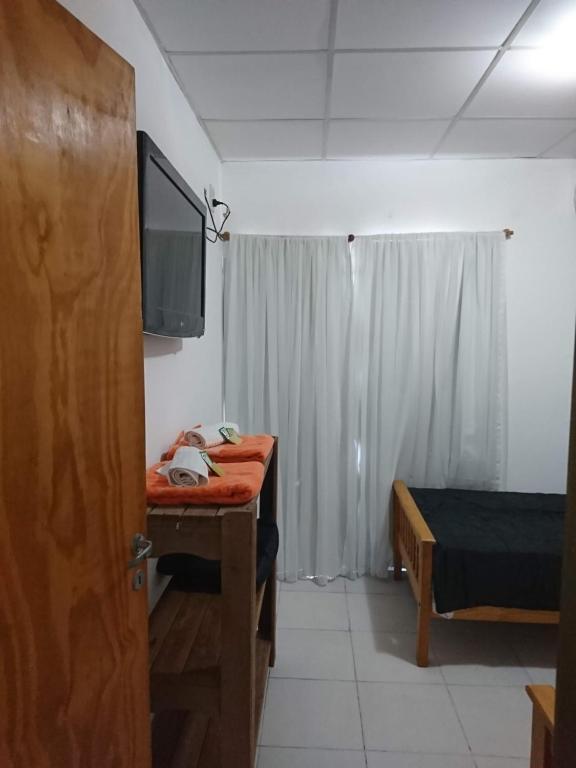 uma sala com um quarto com uma cama e uma televisão em DEPARTAMENTO TEMPORARIO DONOVAN em Resistência