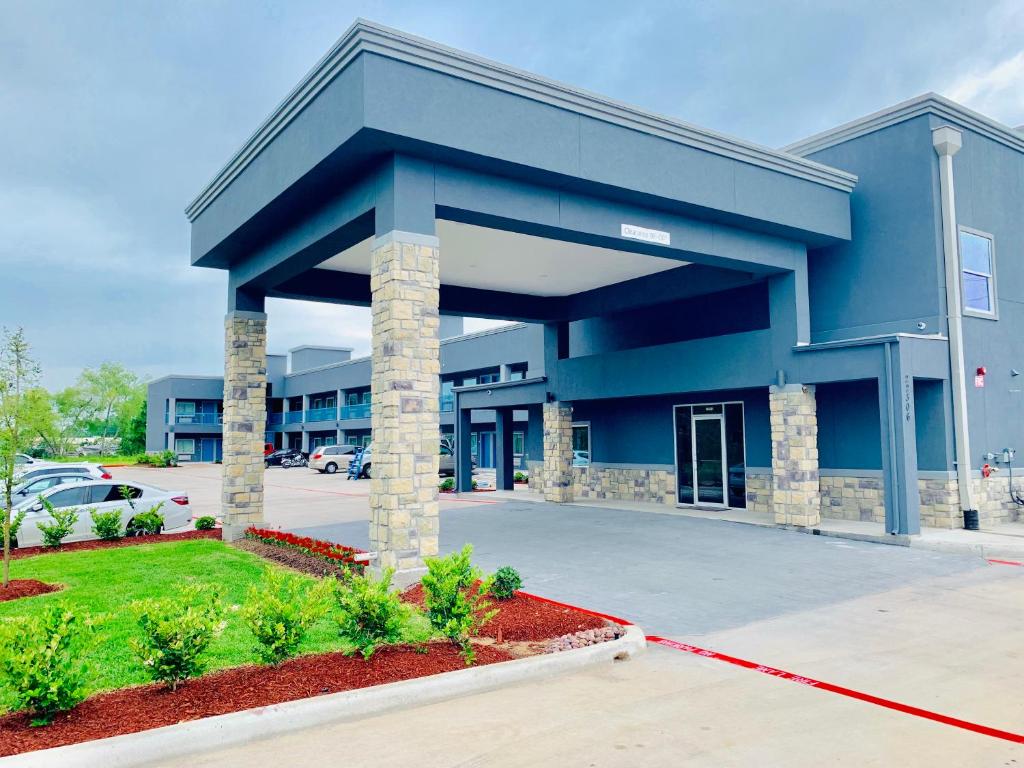 a large blue building with a parking lot at Americas Best Value Inn & Suites Porter North Houston in Porter
