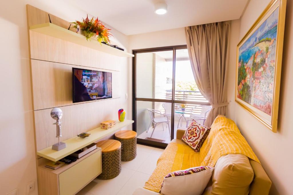 a bedroom with a yellow bed and a balcony at Eco Summer Flat Tambaú in João Pessoa