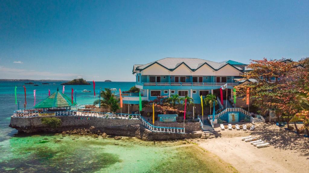 a building on the beach with the water around it at Blue Corals Beach Resort in Malapascua Island