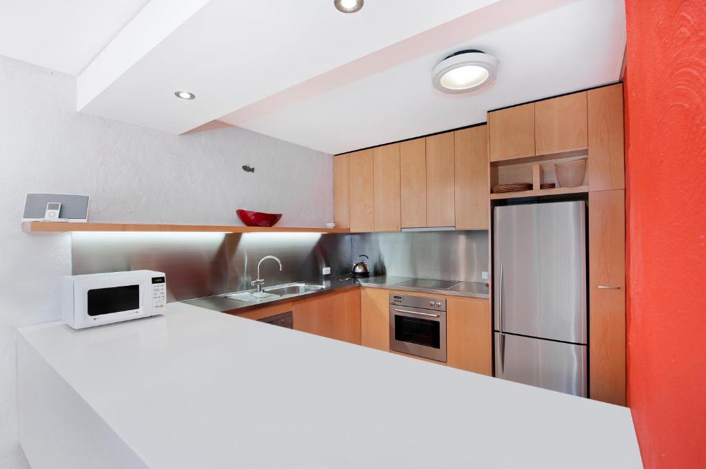 a kitchen with wooden cabinets and a white counter top at 1/18 Allambi Rise in Noosa Heads