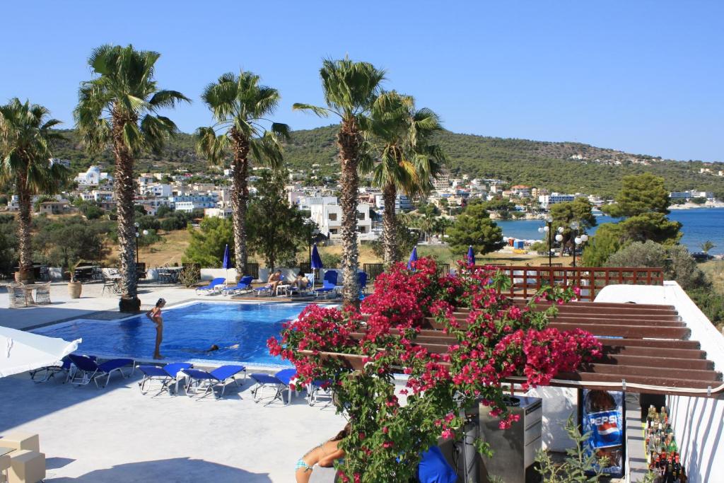 widok na basen w ośrodku z palmami w obiekcie Hotel Blue Fountain w miejscowości Agia Marina