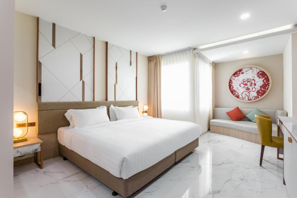 a bedroom with a large bed and a couch at The 8 Hotel Udonthani in Udon Thani