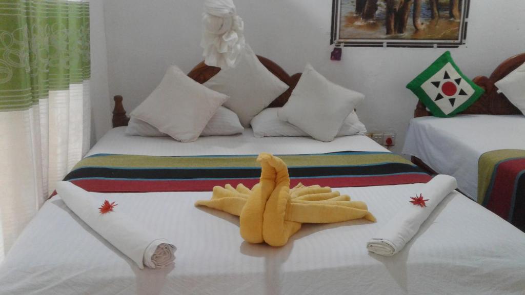 a bed with two stuffed animals sitting on top of it at Kalana Homestay in Sigiriya