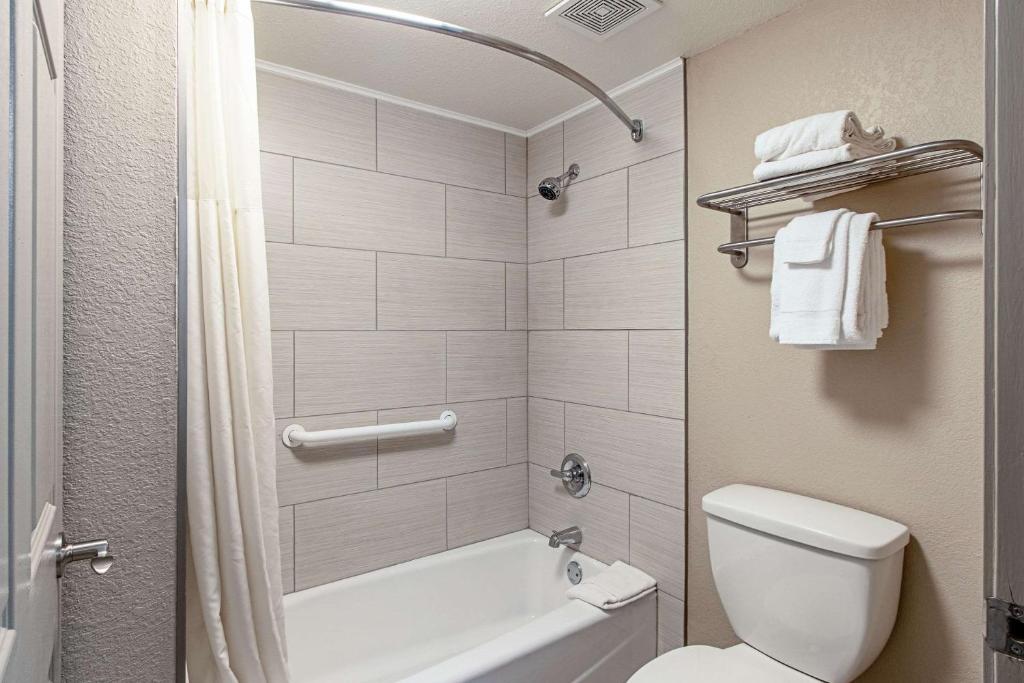 un bagno con vasca, WC e doccia di Econo Lodge Kingsville a Kingsville
