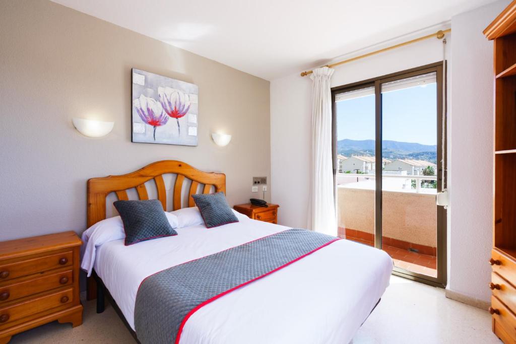 um quarto com uma cama e uma grande janela em Hotel Costa Andaluza em Motril