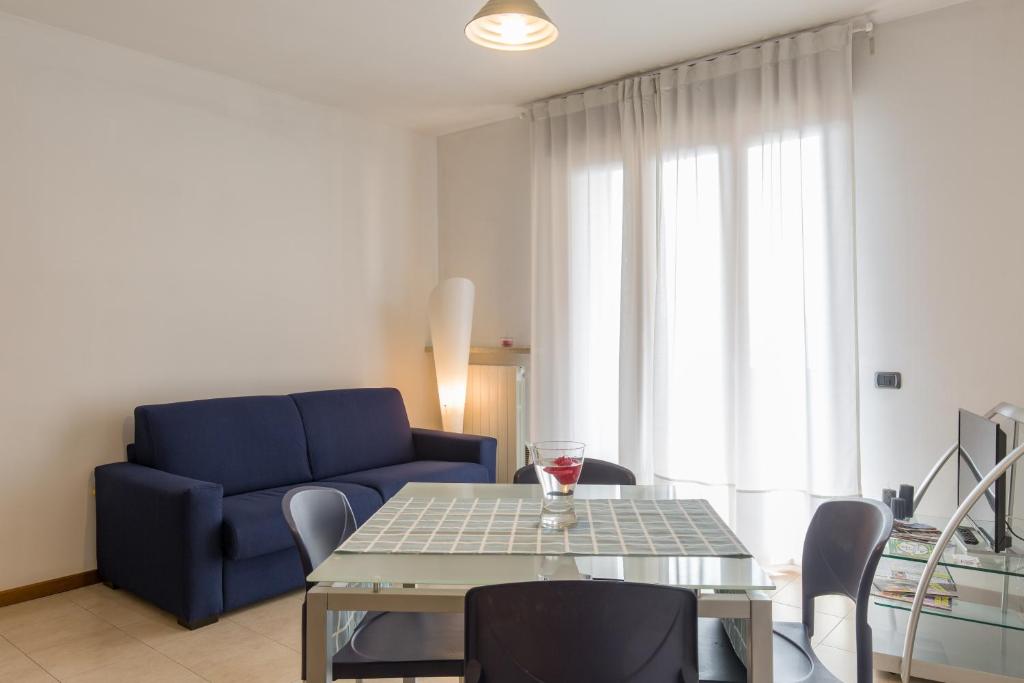 ein Wohnzimmer mit einem blauen Sofa und einem Tisch in der Unterkunft Appartamento Verona Fiera e Centro in Verona