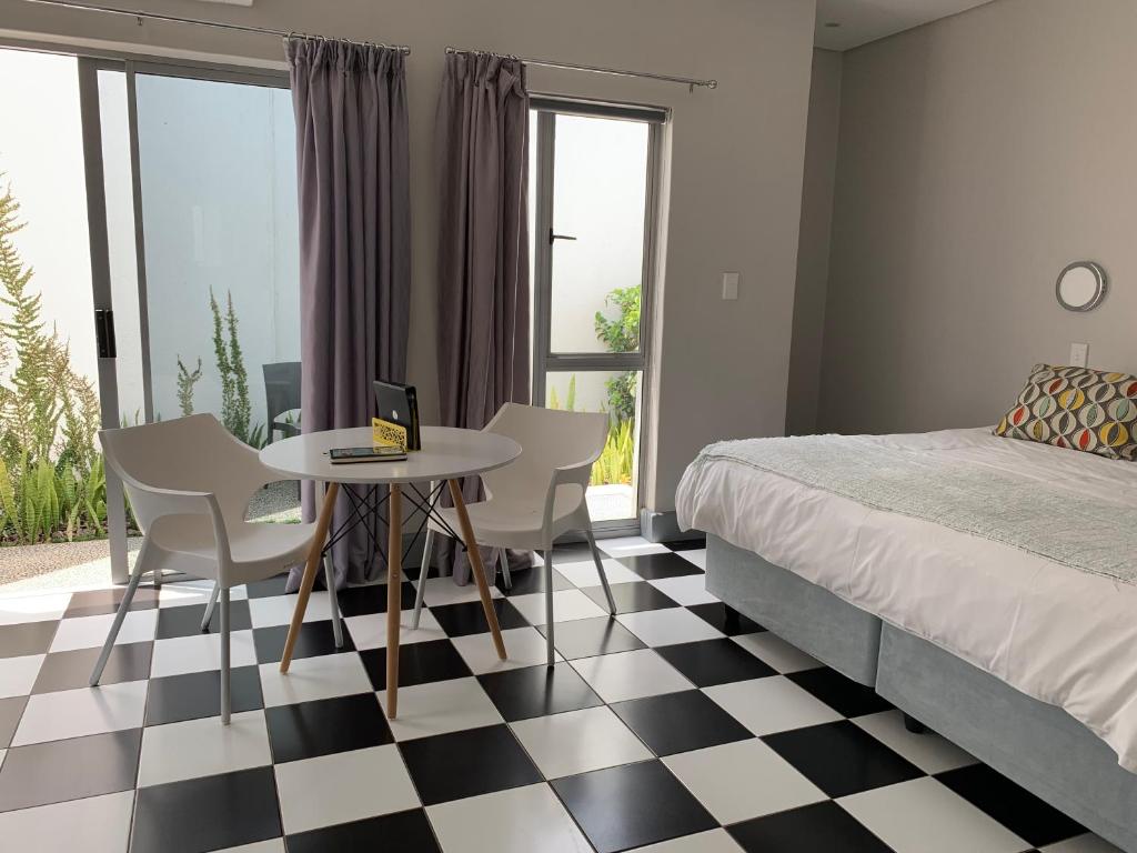 een slaapkamer met een zwart-wit geruite vloer bij HP Twelve Accommodation in Nelspruit