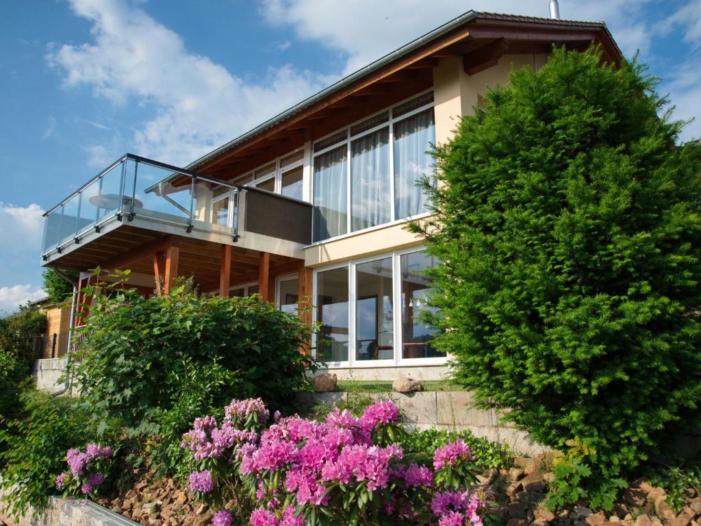 una casa con finestre in vetro e fiori viola di Luxurious Apartment in Waldeck with Sauna a Waldeck