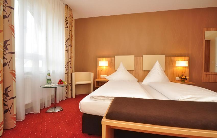 una camera d'albergo con due letti e una finestra di Zellers Pension a Markt Erlbach