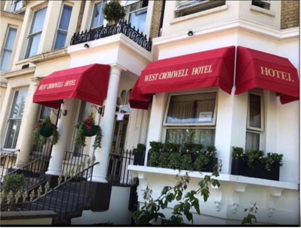 ロンドンにあるウエスト クロムウェル ホテルの建物横の赤い傘のホテル