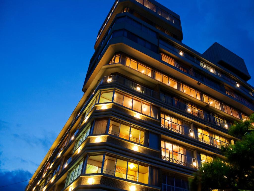 un edificio alto con muchas ventanas por la noche en Kaigetsukan en Sumoto