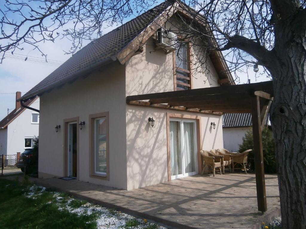 Casa blanca con porche y árbol en Lipót-Haus, en Lipót
