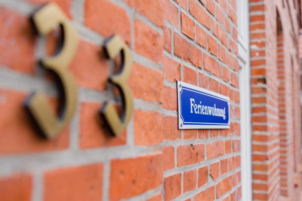 a blue sign on the side of a brick building at Leer Innenstadt 1 in Leer