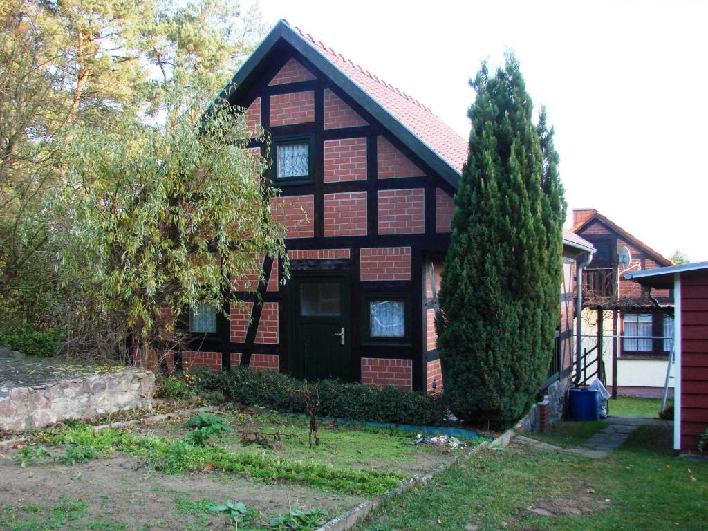 a brown house with a black door and a tree at Ferienhaus Bildt in Kolpinsee
