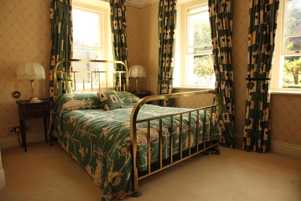 韋斯特波特的住宿－洛斯考茵旅館，一间卧室设有一张床和两个窗户。