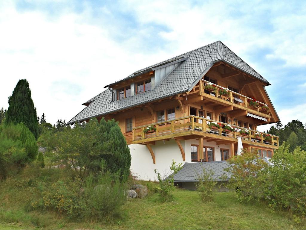 uma grande casa de madeira com um telhado de gambrel em Flat near the ski area in Urberg em Urberg