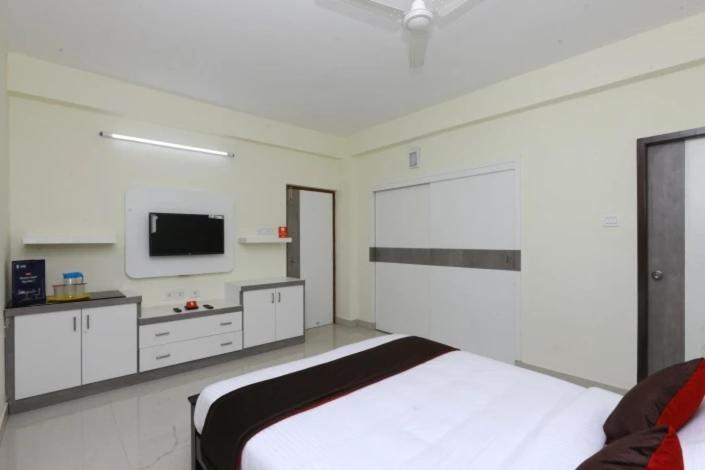 a white bedroom with a bed and a tv at THE POSH RESIDENCY, ECR in Chennai