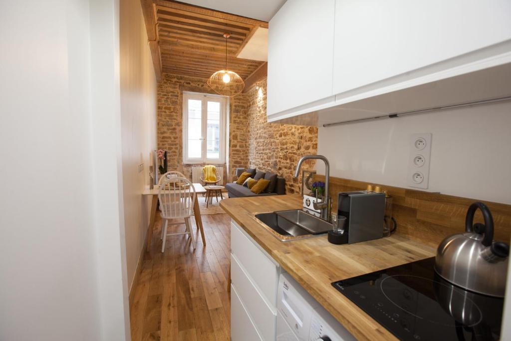 a kitchen with white cabinets and a counter top at Hamac Suites - Studio Ainay 4 - Hyper centre Lyon in Lyon