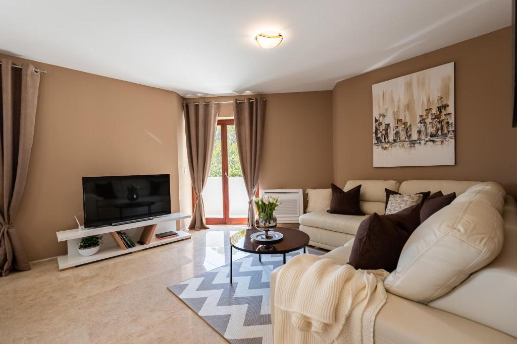 ein Wohnzimmer mit einem weißen Sofa und einem TV in der Unterkunft Zen Luxury Apartments in Zadar