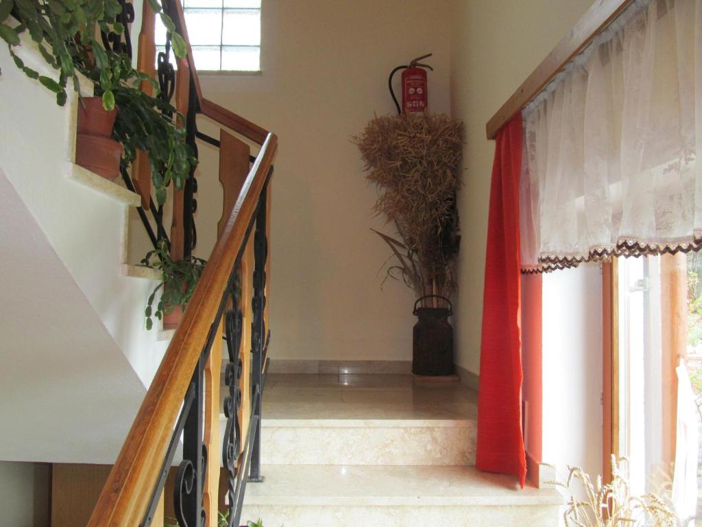 a hallway with a staircase with a red curtain and plants at Appartement Weingut Schoberhof in Bad Gleichenberg