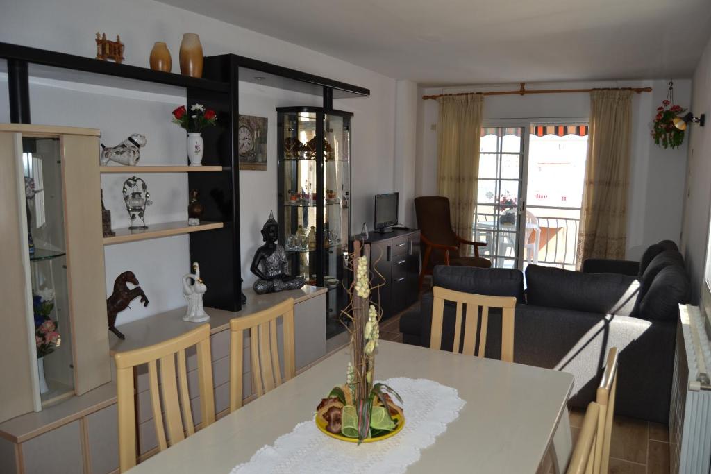 a dining room and living room with a table and chairs at Villa Delfín in Calafell